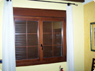 Double sash window with grilles on the glass and roller shutter
