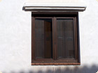 Double sash window with interior veneered flat panel shutters